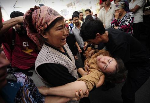 Muslim ethnic Uighurs carry a woman who