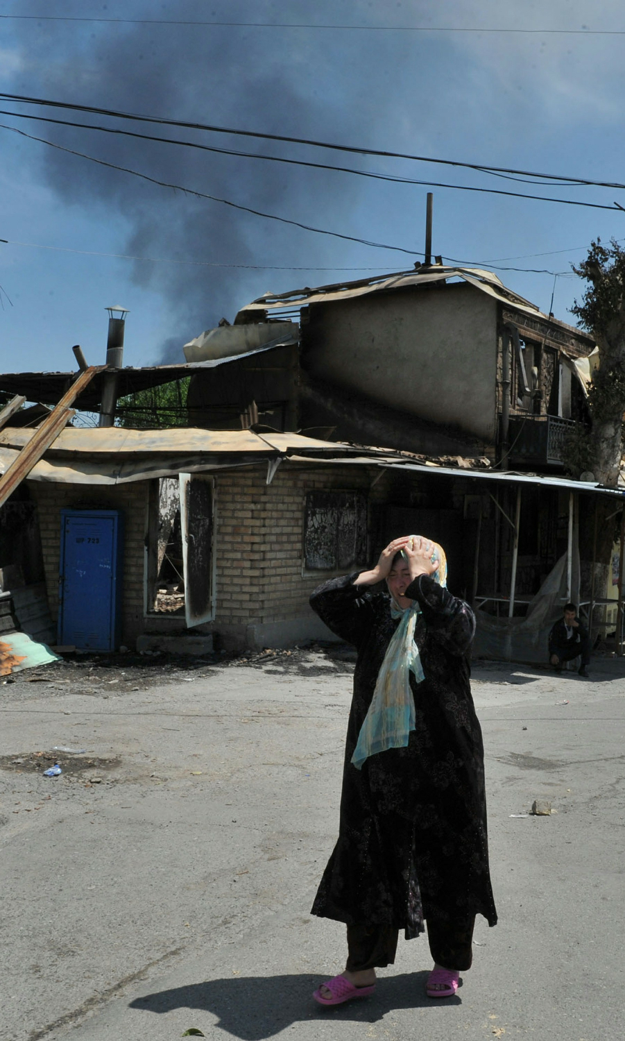 An ethnic Uzbek woman cries as she stand