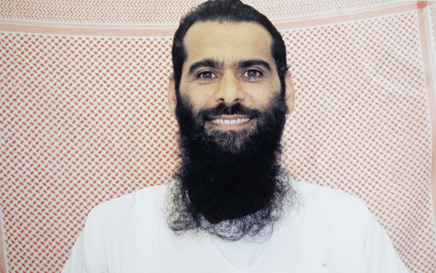 In this undated photo taken by the International Red Cross and provided by the family of Muhammed Rahim al-Afghani, Muhammed Rahim al-Afghani poses for a photo at Guantanamo Bay prison at the U.S. Naval Base in Cuba. Rahim who is being held with the most significant terrorism suspects in U.S. custody has apparently gained extensive knowledge of western pop culture in Guantanamo's Camp 7: the top secret prison-within-a-prison in Guantanamo Bay. Nearly five years ago, Rahim became the last prisoner sent to Guantanamo. He was accused of helping Osama bin Laden elude capture. (AP Photo/International Red Cross via Rahim family)
