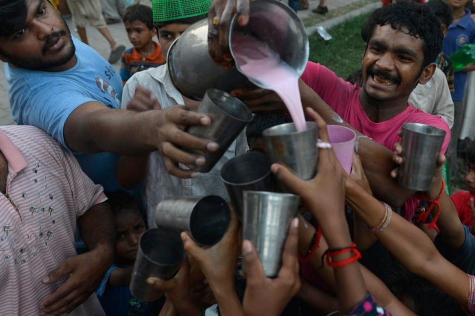 Pakistani Muslim devotees receive a sweet drink to break their fast during the Muslim fasting month of Ramadan in Lahore on June 19, 2015. Islam’s holy month of Ramadan is celebrated by Muslims worldwide. 