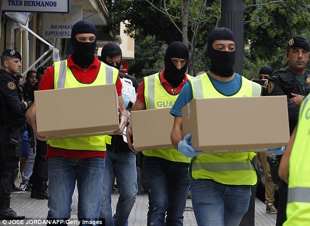 2BFE55A700000578-3223565-Balaclava_clad_police_officers_were_seen_carrying_boxes_of_evide-a-9_1441500806480