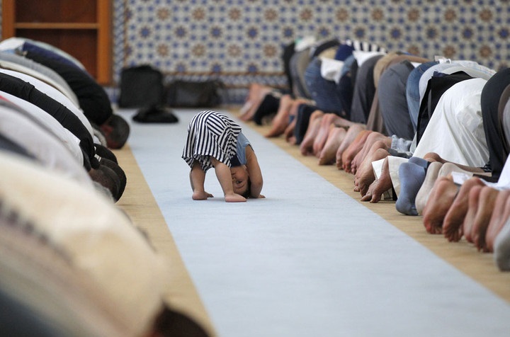  طفل منبهر بالصلاة و يقلد المصلين في مدينة ستراسبورغ الفرسية  بينما كان المصلون يؤدون صلاة الظهر 